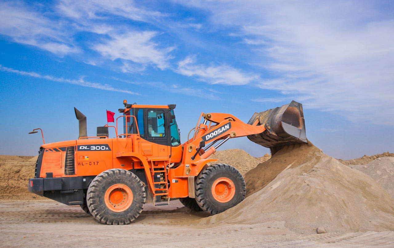 Crafting Captivating Headlines: Your awesome post title goes here An orange bulldozer at work, moving sand under a clear blue sky on a construction site.