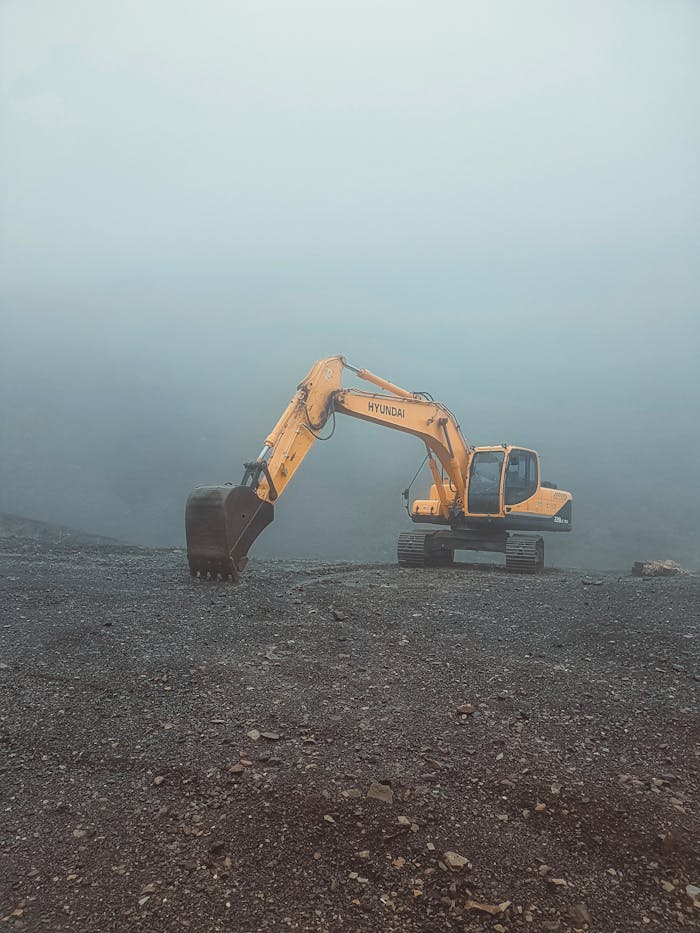Mastering the First Impression: Your intriguing post title goes here A solitary excavator on a misty day in Krasnaya Polyana, Russia, set against a barren landscape.