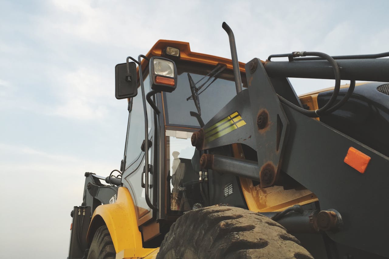 The Art of Drawing Readers In: Your attractive post title goes here Detailed view of a yellow excavator against a clear sky at a construction site.